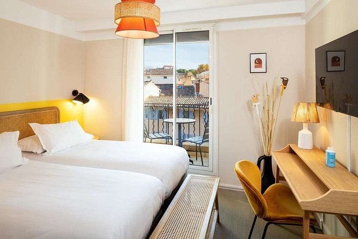 Chambre de l'Hôtel Escaletto, lit double et bureau devant une baie vitrée