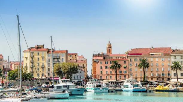 Port d'Ajaccio, bateaux de plaisance amarrés devant les façades pastel de la vieille ville