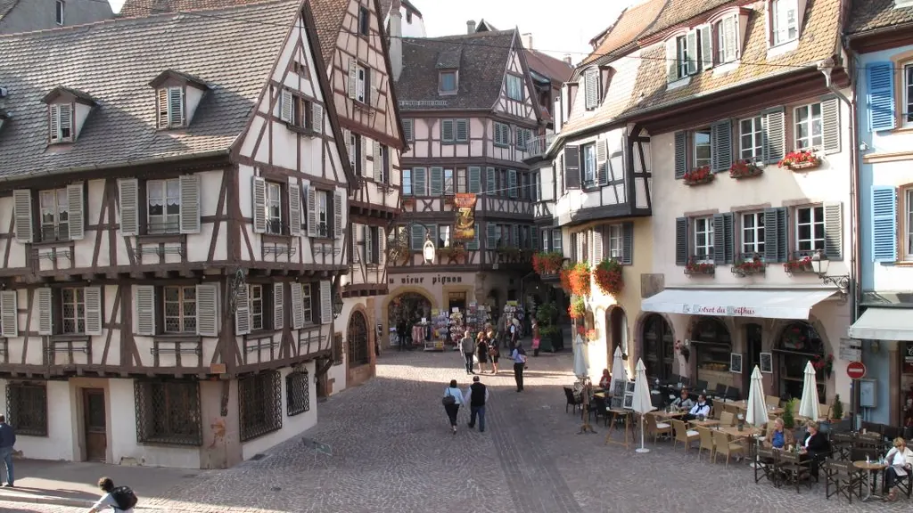 Rue pavée de Colmar bordée de maisons alsaciennes à colombages et de devantures fleuries